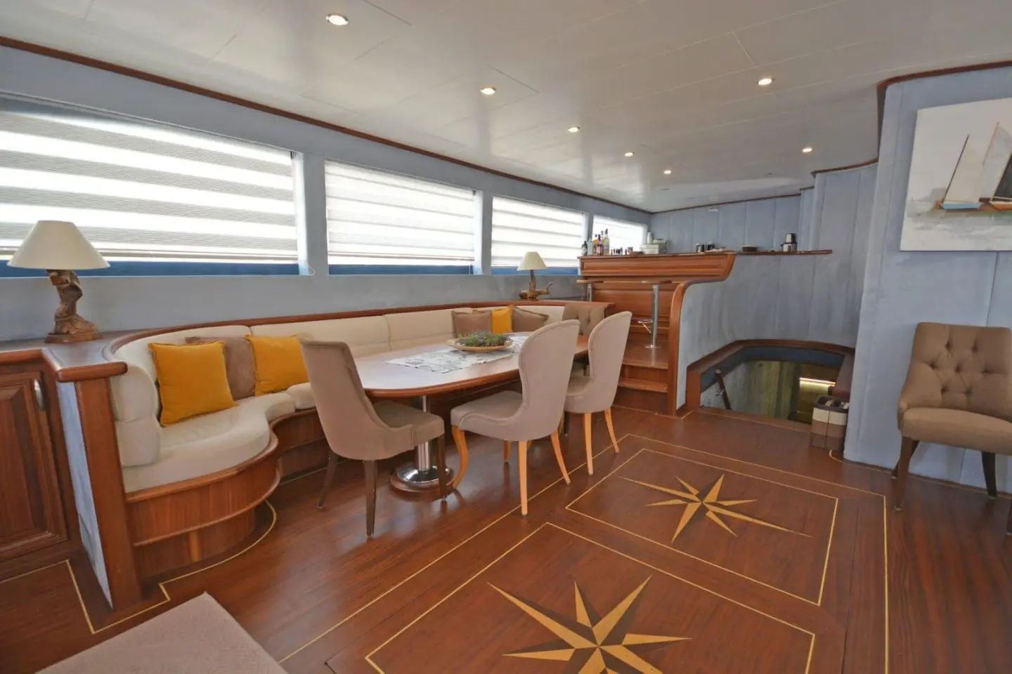Bella Mare yacht interior dining area with large windows and wooden floor