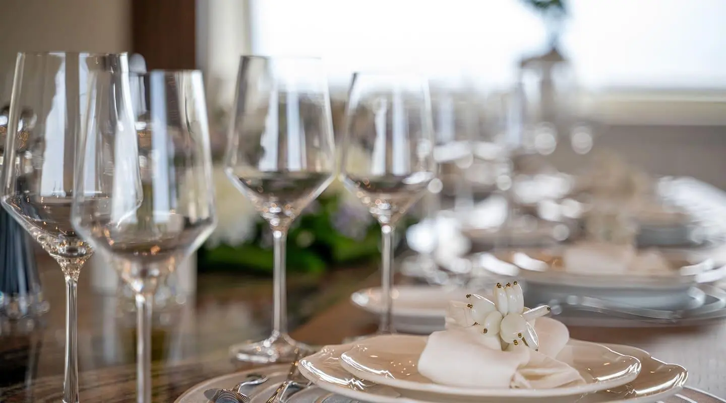 Pareaki II motor yacht table setting with plates and champagne flutes
