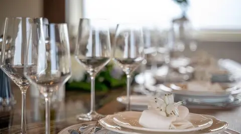 Pareaki II motor yacht table setting with plates and champagne flutes