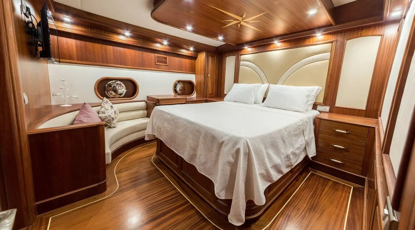 Halcon Del Mar yacht interior with two twin beds, warm wood panels, and porthole window