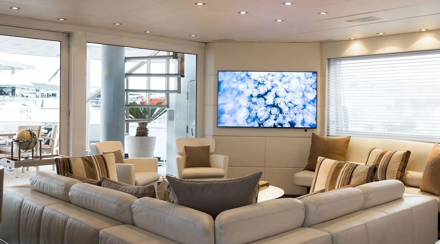Luxurious yacht salon on Brooklyn with beige sofas and a large wall screen