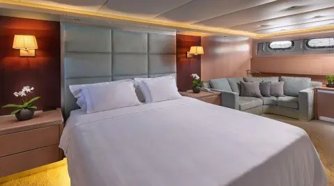 Magix yacht bedroom with two large beds, wood headboard, soft lighting