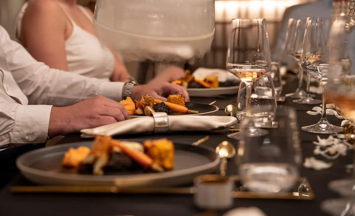 Nocturno yacht dining on deck at sunset with plated meals and candles