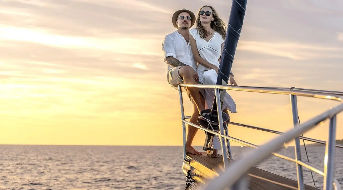 Yacht named Smart Spirit at sunset with two people on the bow railing