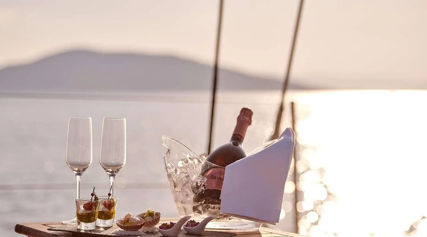 Aizu luxury yacht at sunset, deck table set with glasses and plates