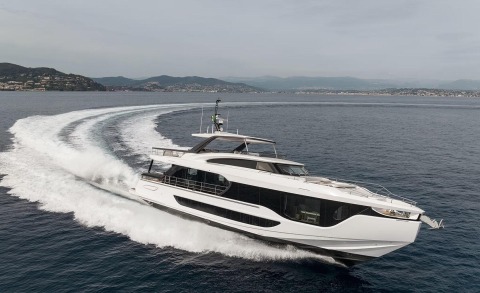 White motor yacht speeding across open sea, side view