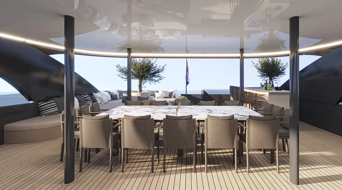 Large wooden deck dining table with chairs and sea view in the background