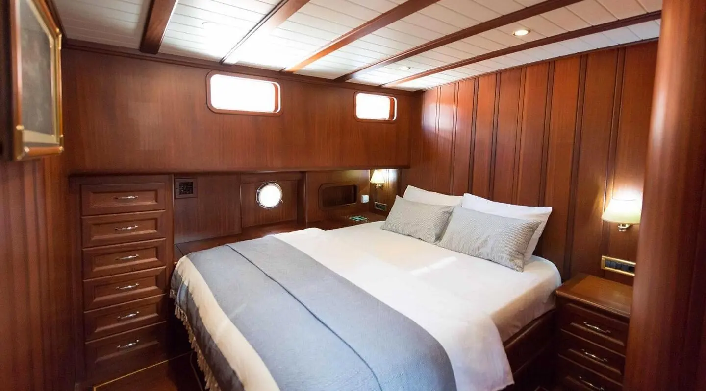 Double cabin aboard Primadonna gulet showing neatly made beds and wood interior