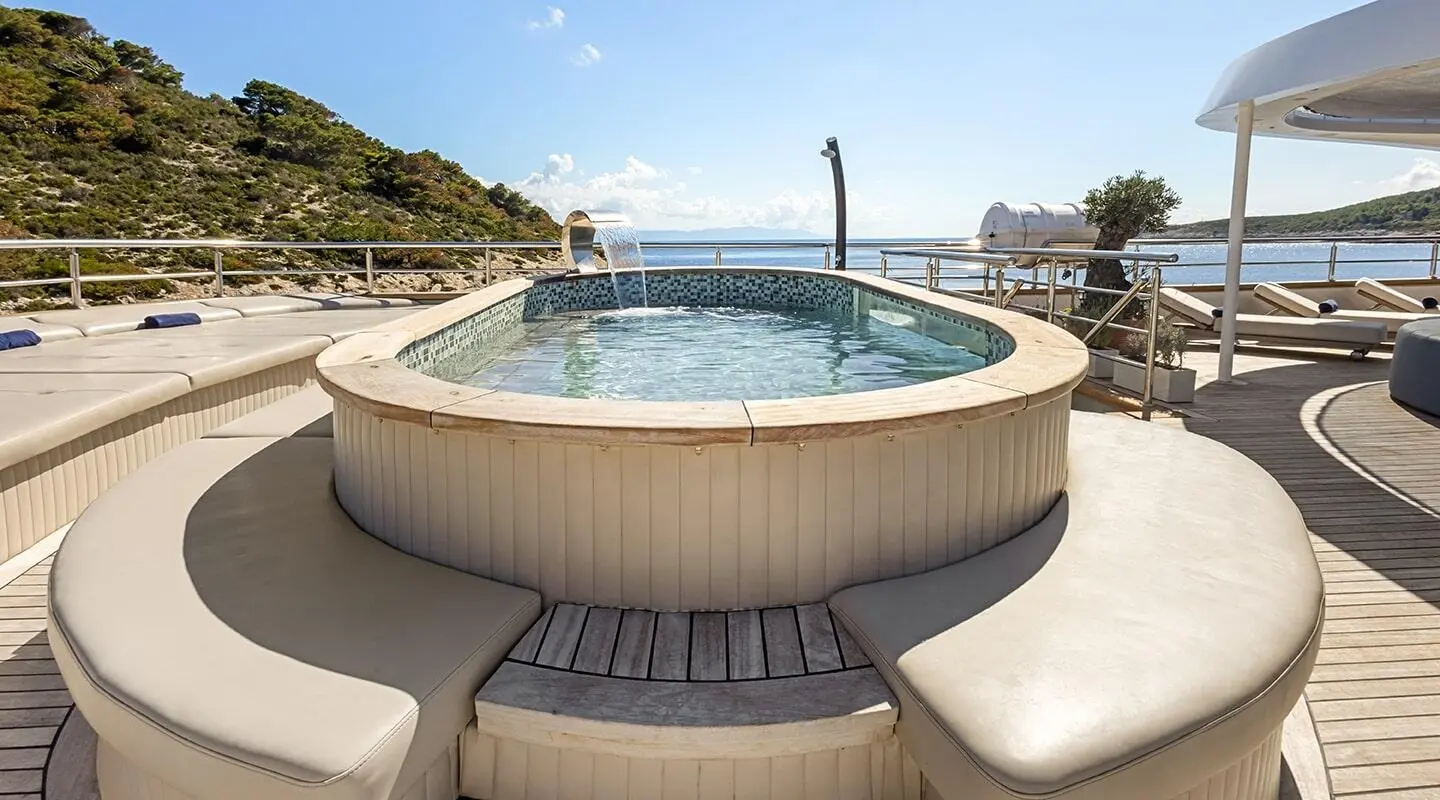 Bella motor yacht sundeck with a circular pool and sun loungers
