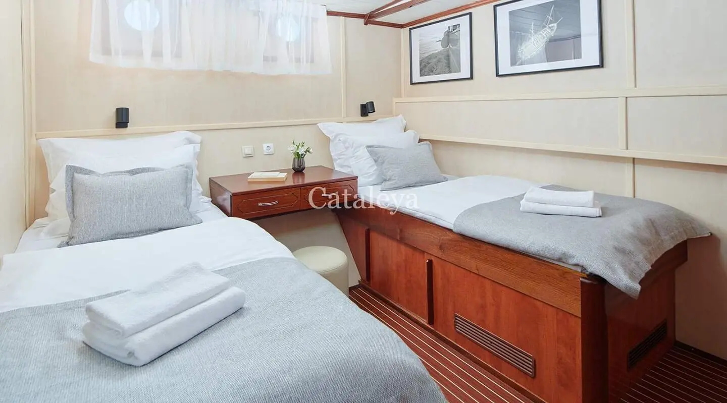 Cataleya luxury yacht twin guest cabin with white bedding and gray accents