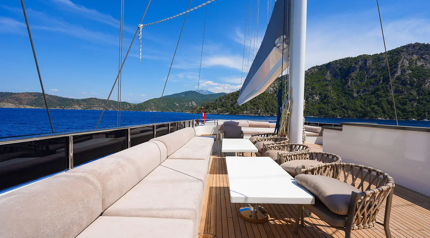 Sun deck of King Of The Sea yacht with white lounge chairs and blue sea