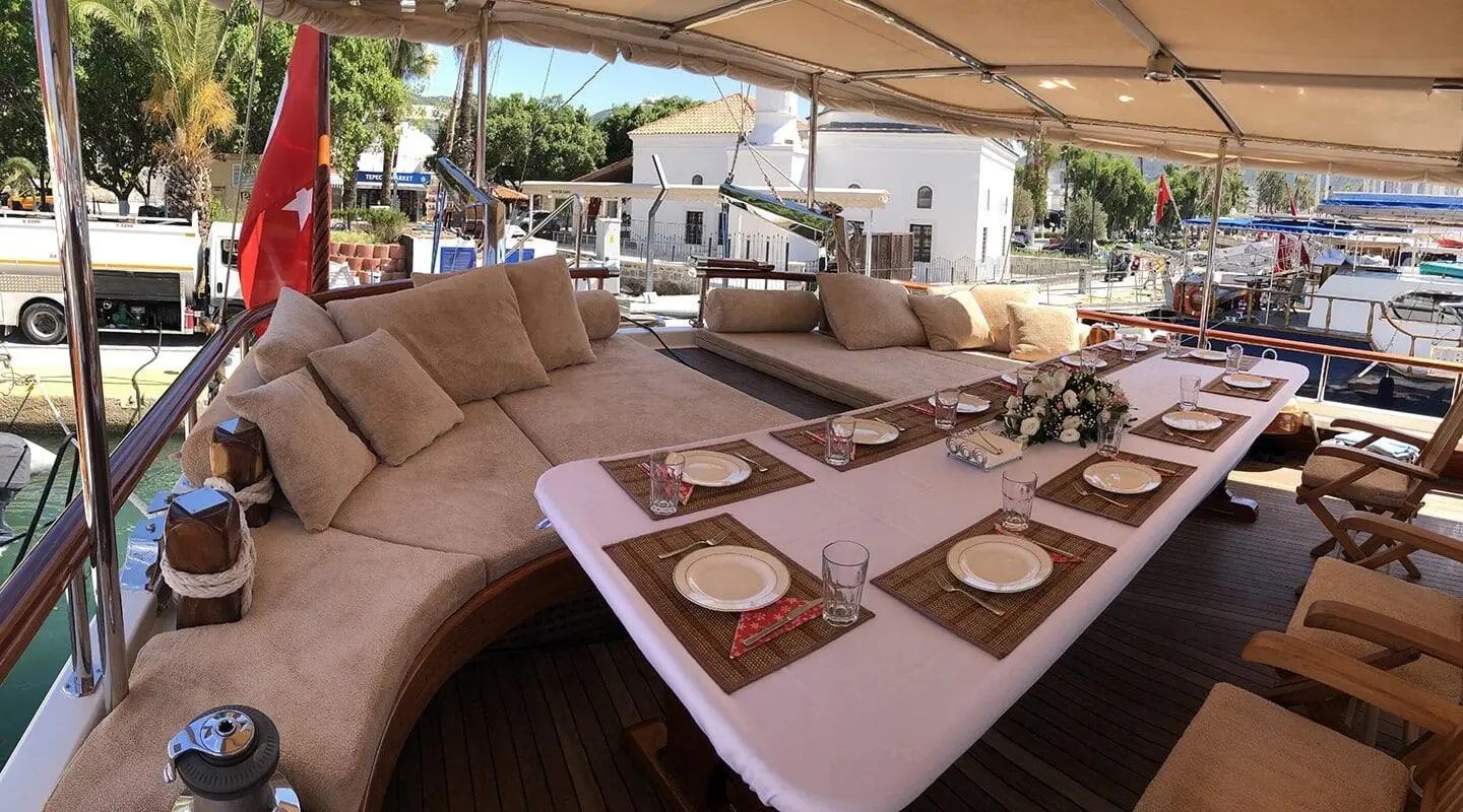 Aft deck dining area aboard Enderim A with cushioned seating and table set for guests