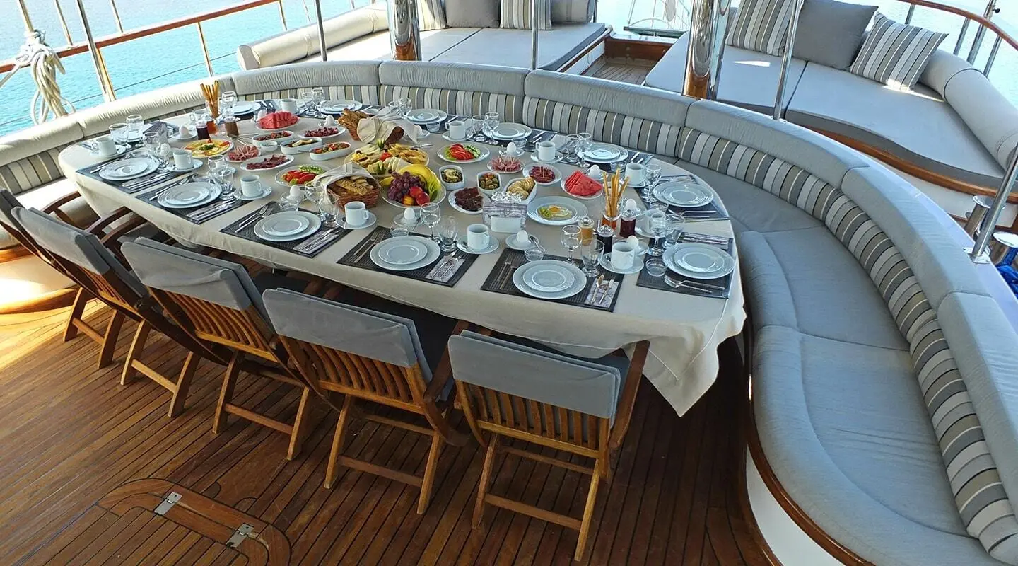Yacht Kaptan Mehmet Bugra table set for sunset aboard sleek sailing gulet with guests