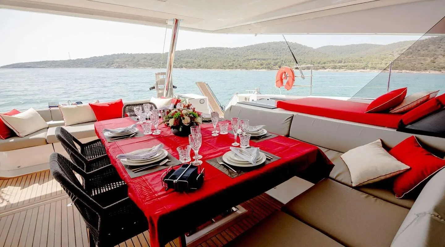 Table set for dining on Astoria yacht deck with red checkered tablecloth