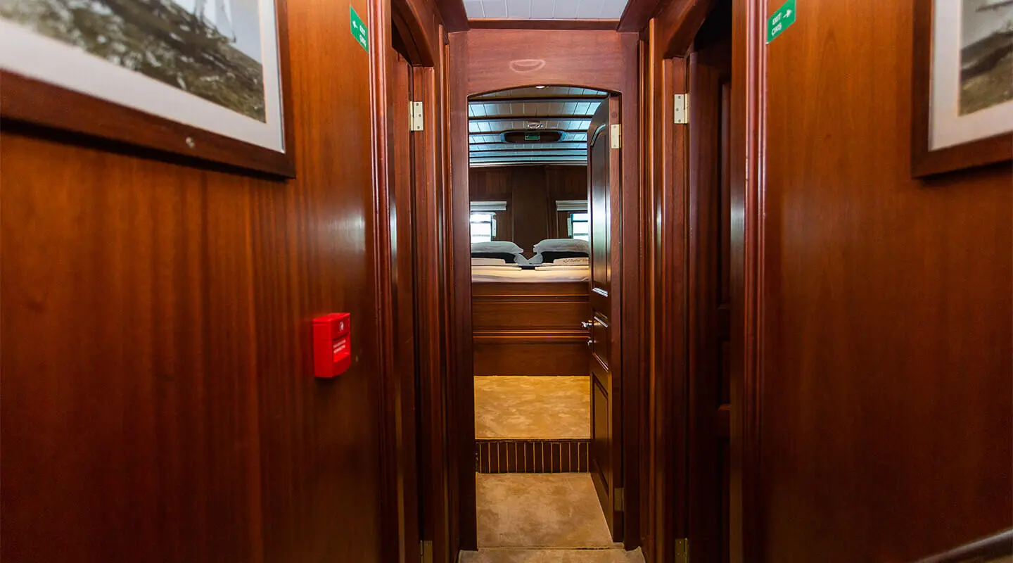 Dolce Vita yacht interior hallway leading to deck with warm wood panels