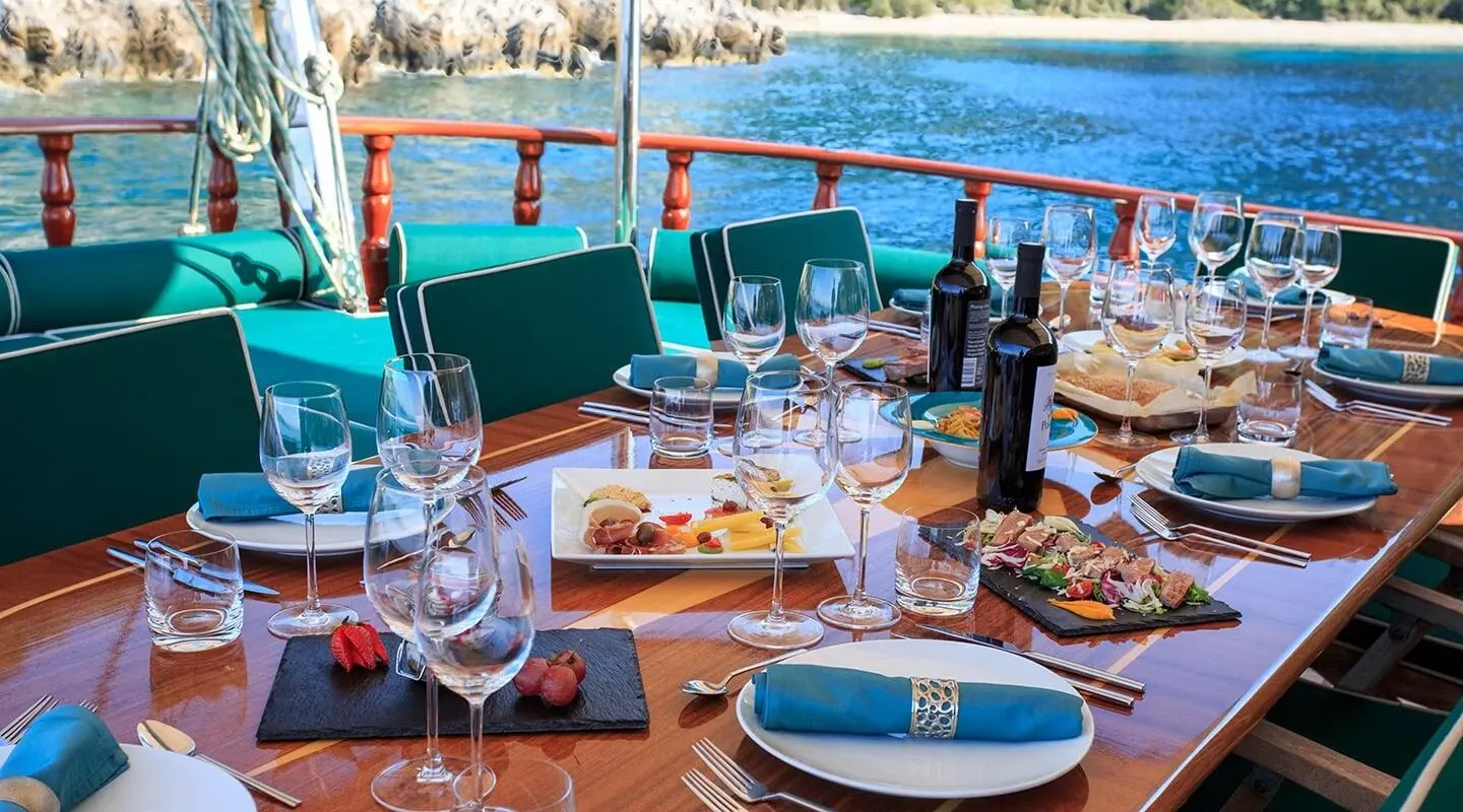 Carpe Diem 7 luxury yacht dining setup on deck at sunset harbor