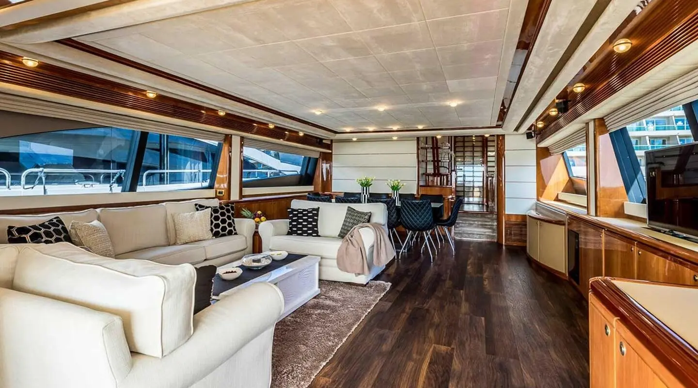 Spacious yacht salon with leather seating, wood floors, and large windows