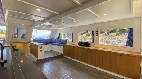 Maske 5 interior: spacious saloon with L-shaped blue cushions and wood cabinetry