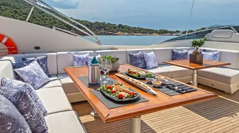 Divine motoryacht flybridge with sun loungers and a wooden deck dining area