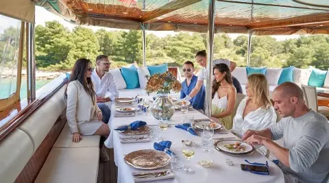 Casablanca yacht dining on deck with guests at sunset meal, elegant table setup