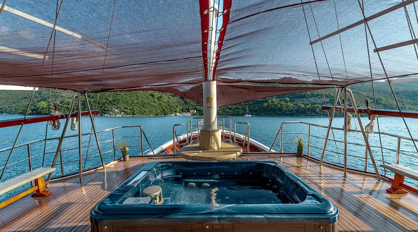 Cesarica yacht deck view at sunset, sail rigging overhead and calm blue water