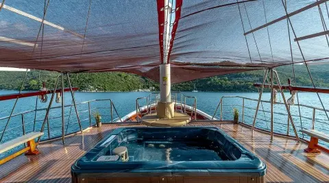 Cesarica yacht deck view at sunset, sail rigging overhead and calm blue water