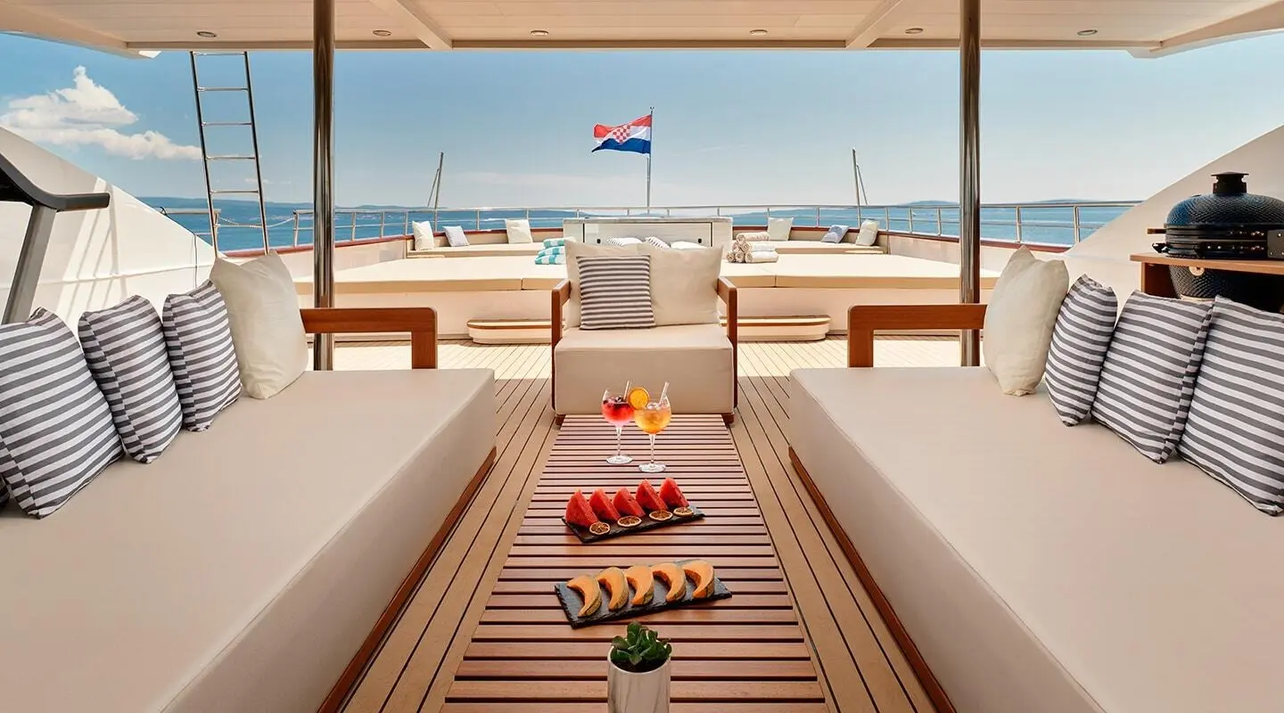 Ohana yacht deck at sunset with lounge chairs and table setting