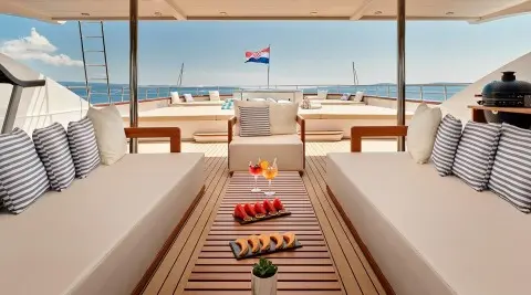 Ohana yacht deck at sunset with lounge chairs and table setting