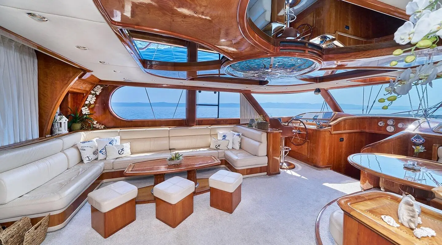 Luxurious yacht interior with wooden deck, seating, and warm sunset glow