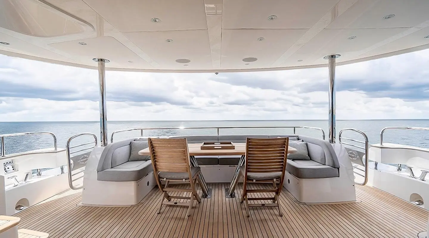 Quantum motor yacht aft deck with seating and folding chairs under open sky