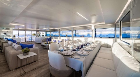 Sea Wolf yacht saloon with dining table and chairs, large windows and interior decor