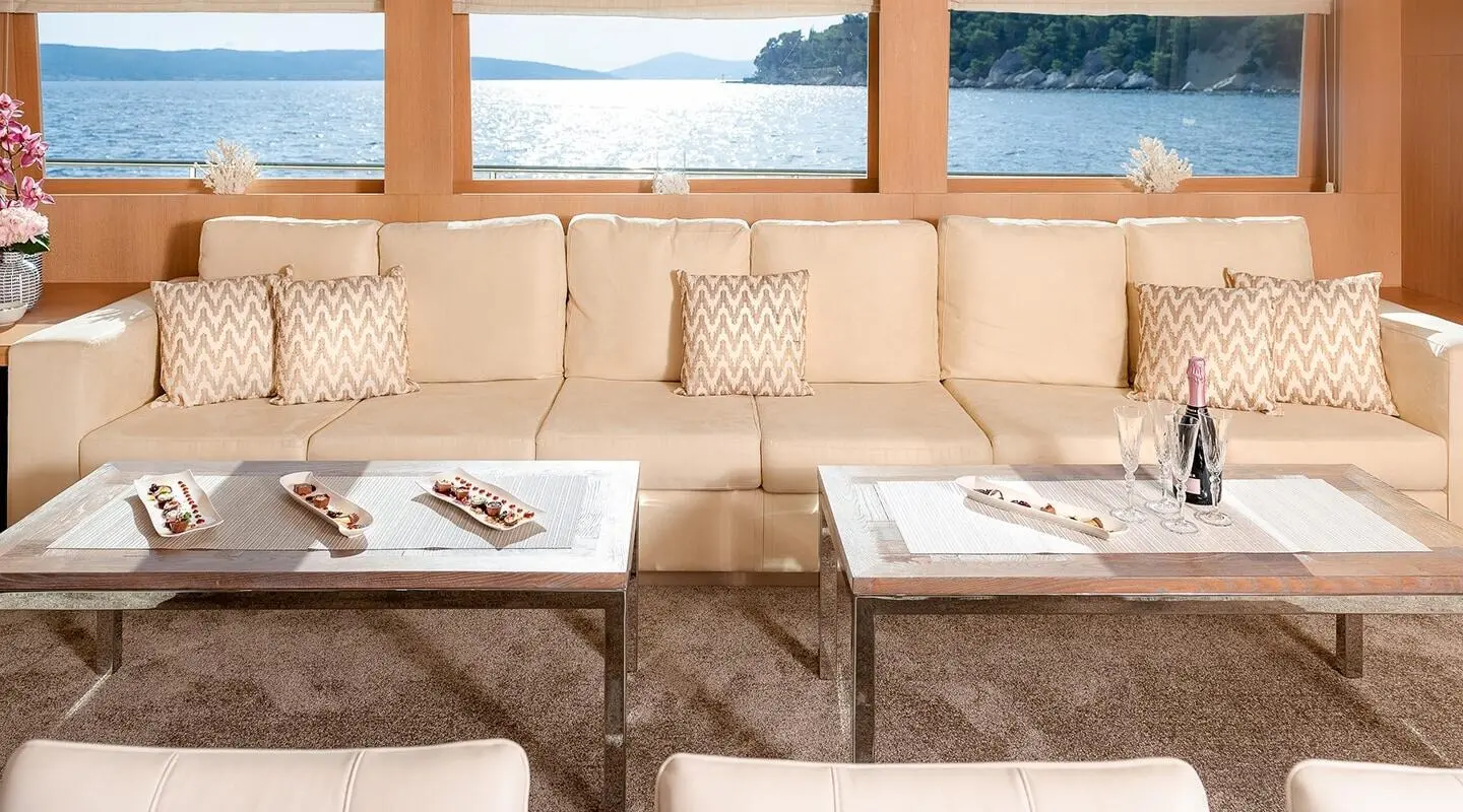Grace yacht salon with cream seating, beige cushions, and a glass coffee table