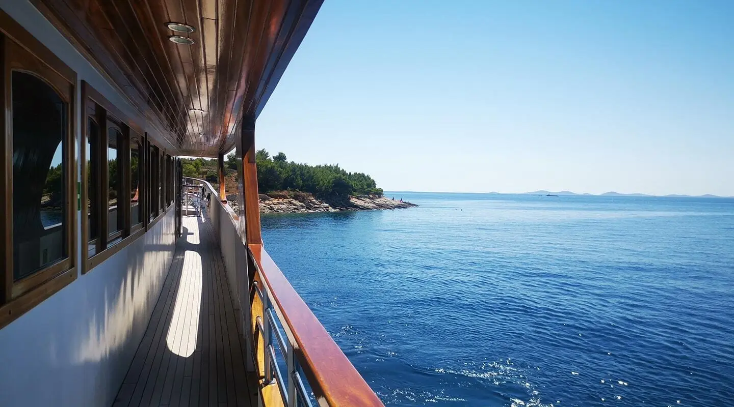 Wide view from deck of Melody yacht; calm blue sea and distant shoreline