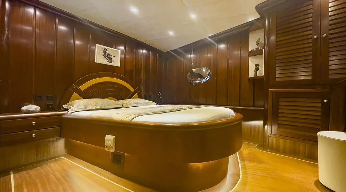 Luxurious Diva Deniz yacht interior with wood panels, curved sofa, warm lighting