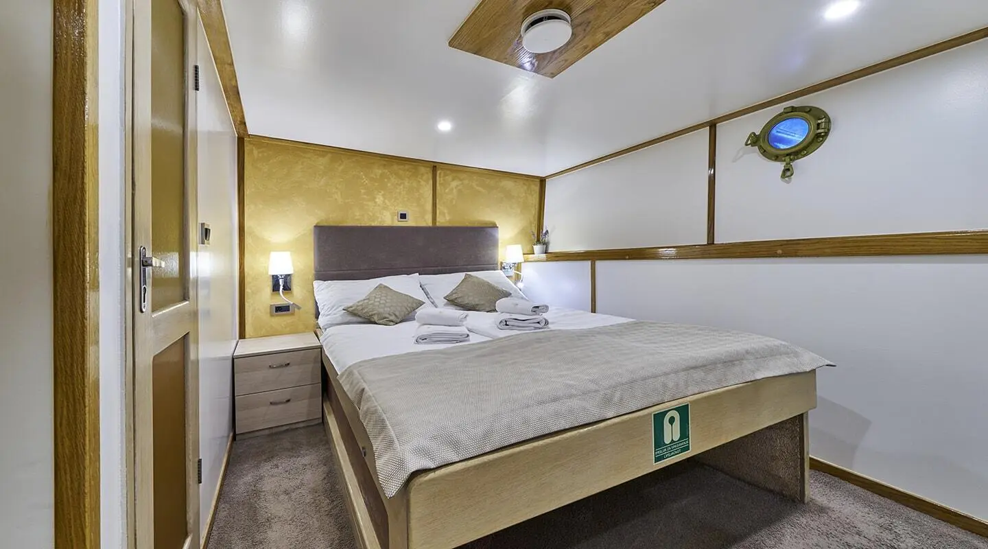 Romanca yacht interior: double cabin with two beds and wooden accents