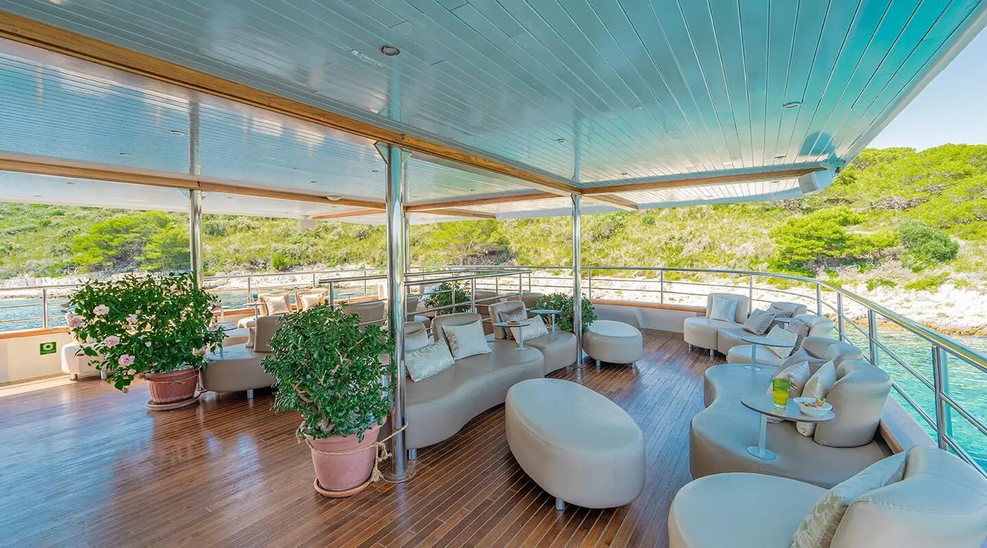 Deck of a Riva luxury yacht with shaded seating area and wicker chairs