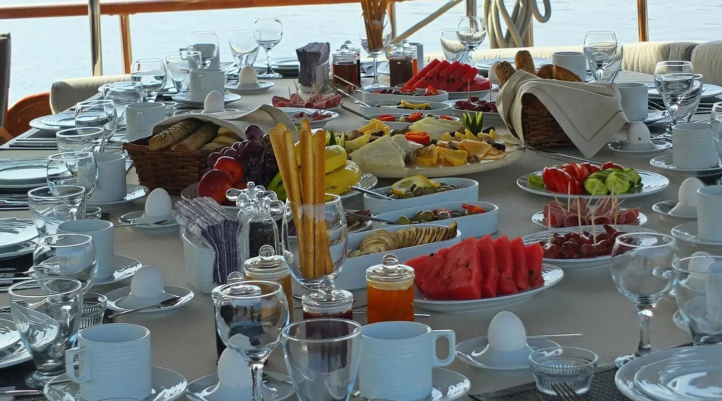 Kaptan Mehmet Bugra luxury gulet at sunset with table set for meals onboard