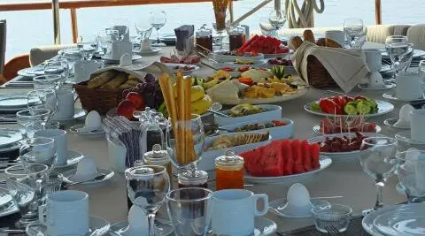 Kaptan Mehmet Bugra luxury gulet at sunset with table set for meals onboard