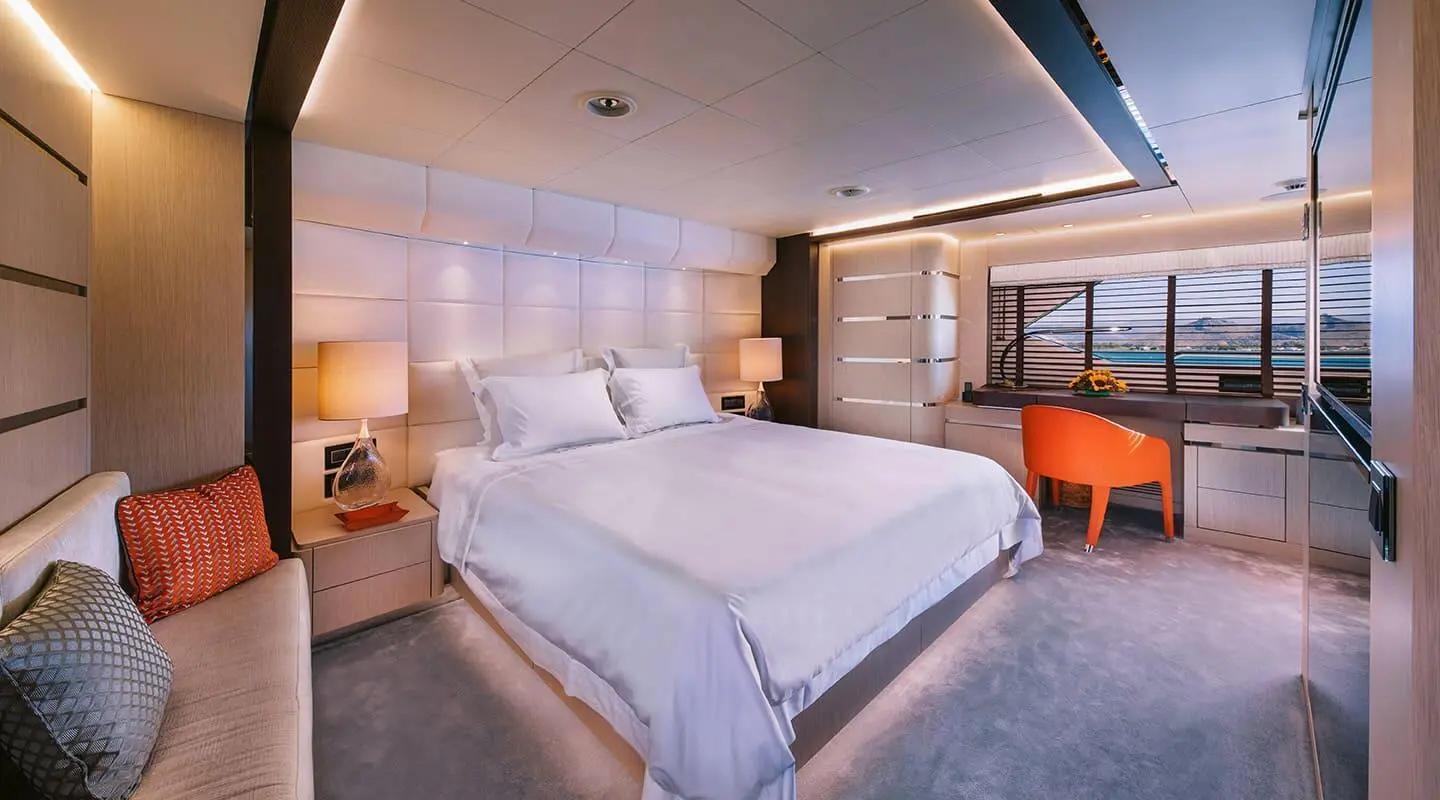 Xana yacht cabin with a bed and bedside tables, window light filtering in