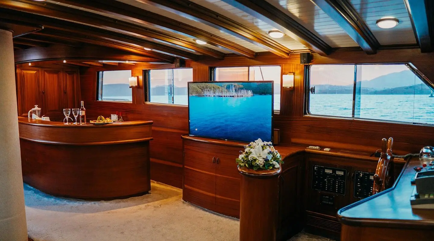 Wood-lined luxury gulet interior with a TV and bar in the lounge