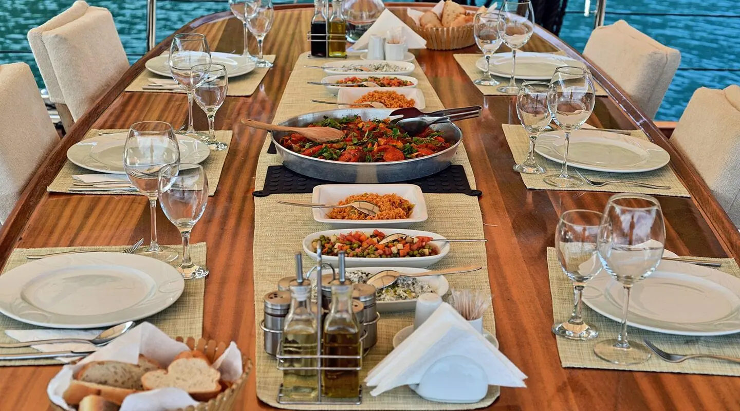 Gulet Derin Deniz yacht dining table set with plates and glasses on deck