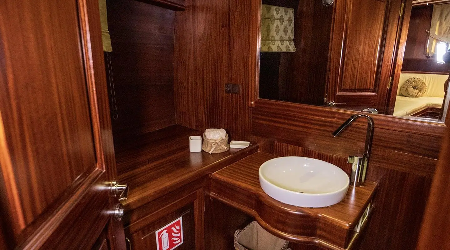 Wood-paneled bathroom aboard Arif Kaptan A yacht with sink and mirror