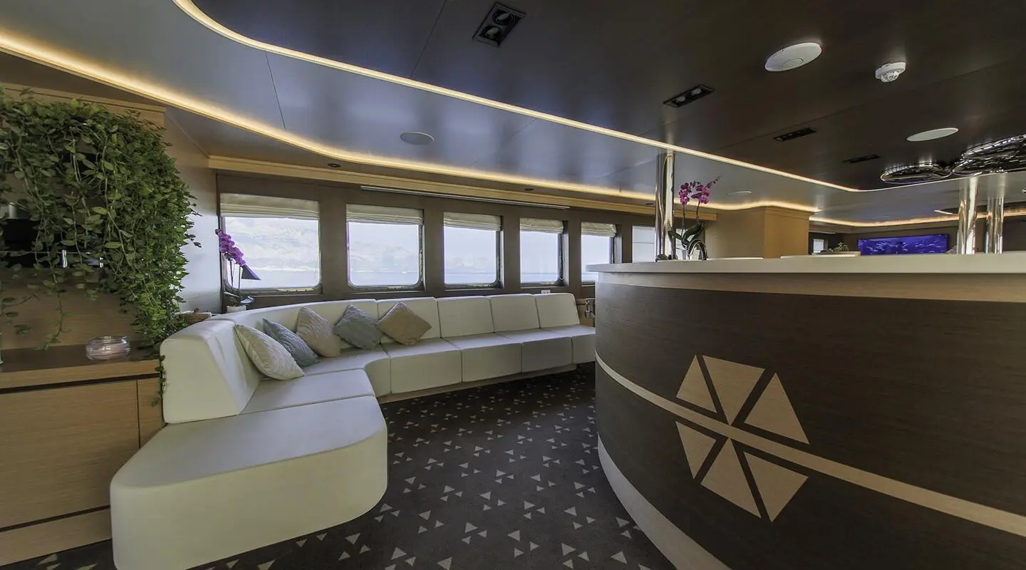 Luxurious interior lounge on Omnia yacht with curved seating and large windows