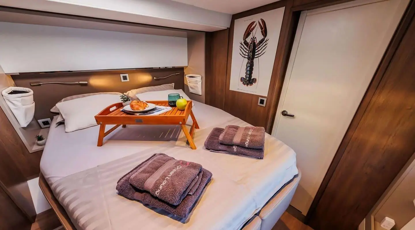 Cozy yacht cabin with two beds, brown cushions, and wall art