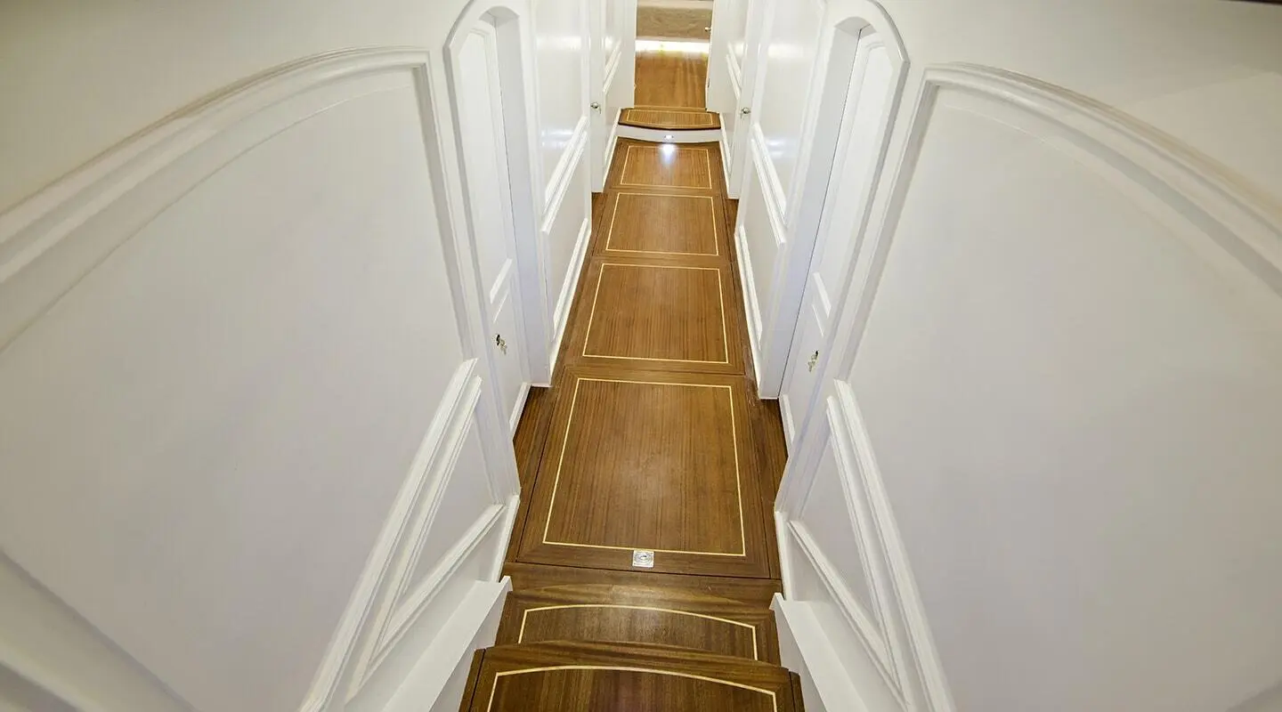 Bella Mare yacht interior corridor with wooden steps and white walls