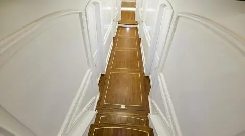 Bella Mare yacht interior corridor with wooden steps and white walls