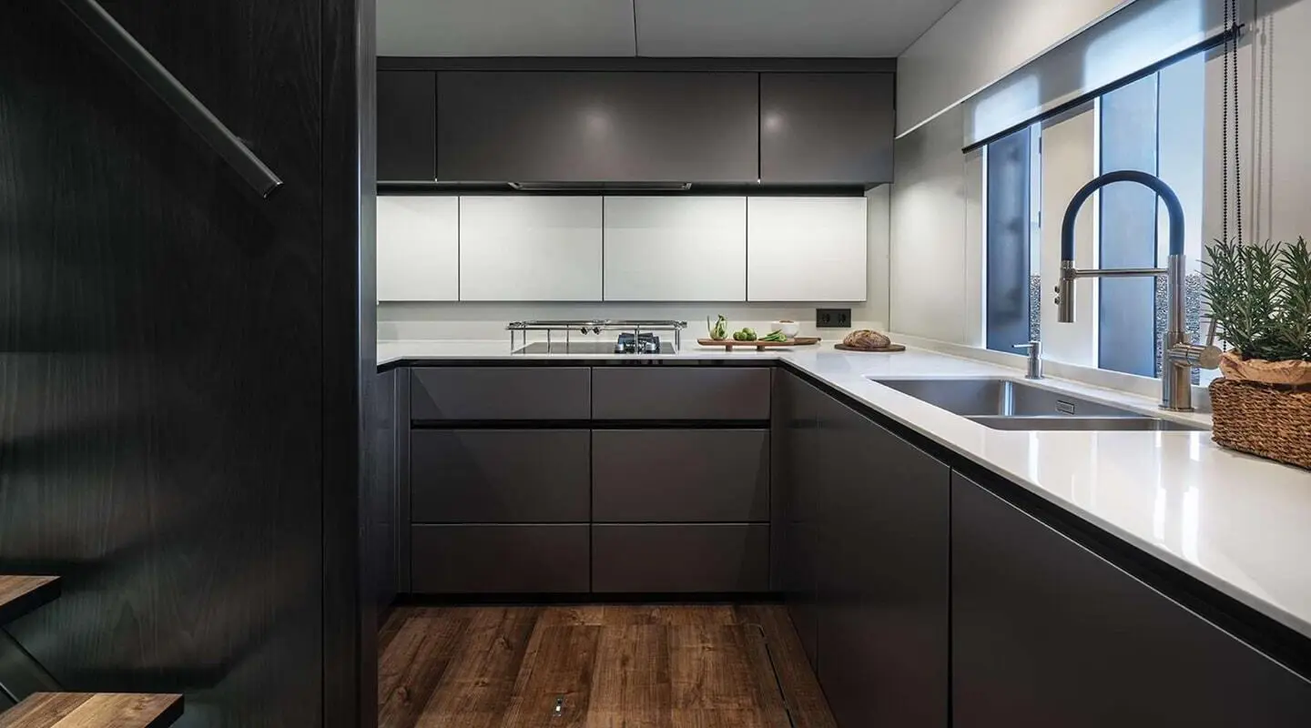 Alteya luxury yacht galley with dark cabinetry, white countertops, and wooden floor