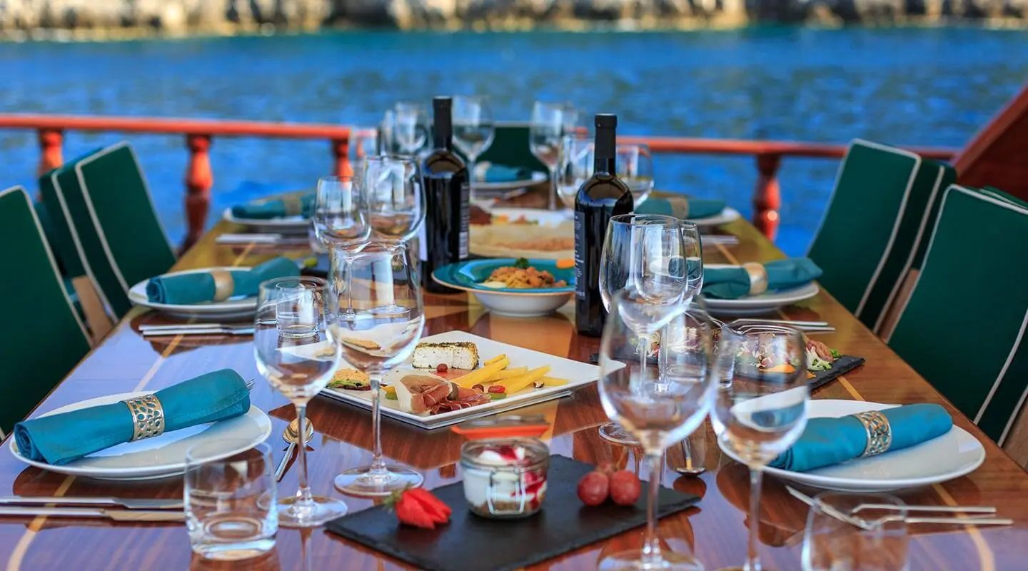 Table set for a meal on a gulet yacht with wine glasses and plates