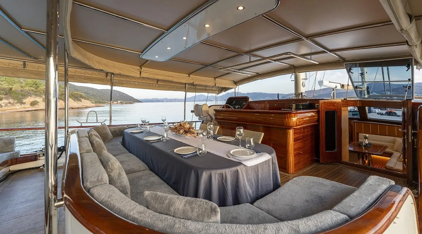 Interior of Gozdem The One yacht: plush gray seating, wooden helm, and glass windows