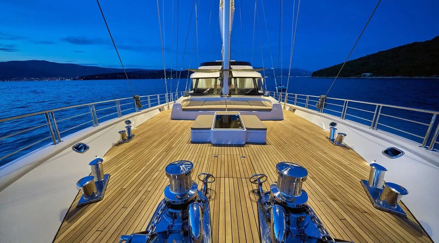 Bow deck of Acapella yacht with lines, railings, and blue sea backdrop